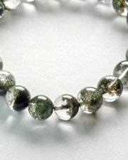 Close-up of Green Phantom Quartz Bracelet (Light Inclusion) on a light background